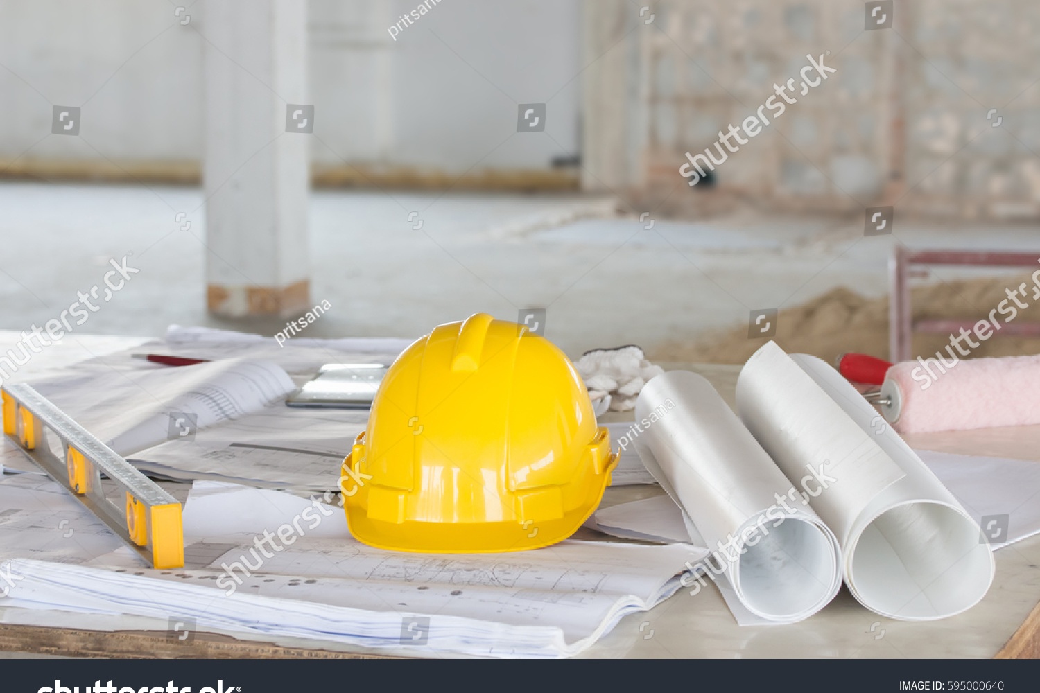 Construction planning session with blueprints and safety equipment